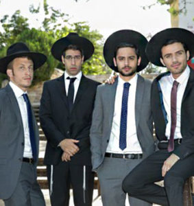 Image shows four young men wearing suits and fedoras. 