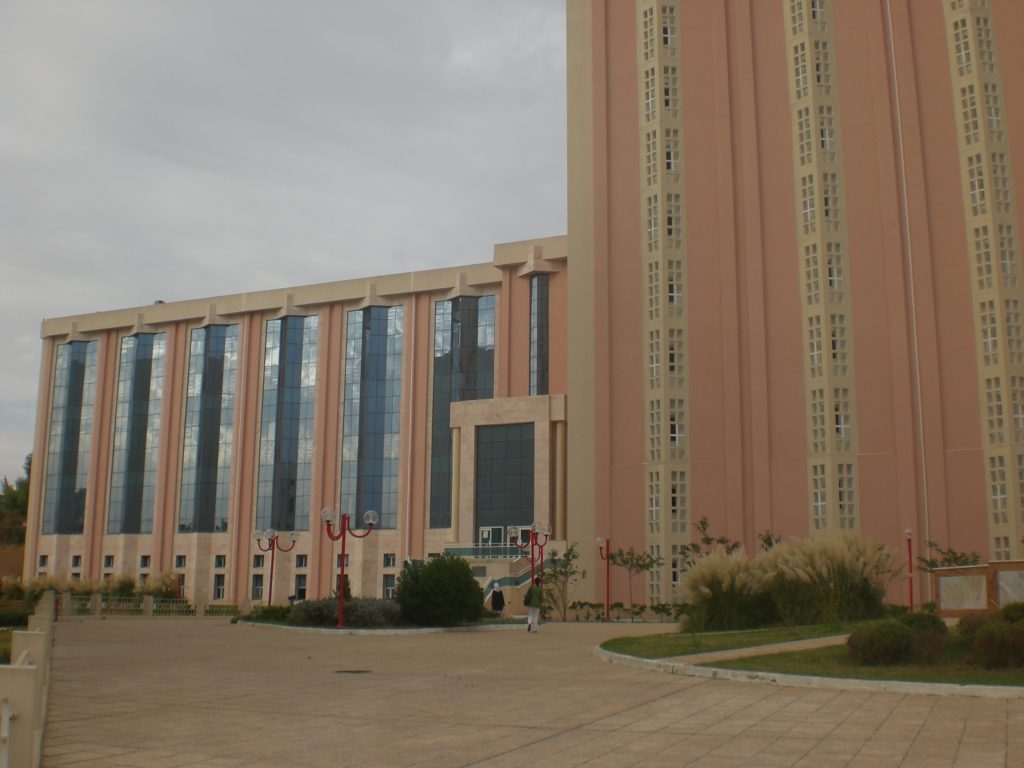 Photograph of the National Library of Tunisia, a large, red brick building with strong, vertical elements.