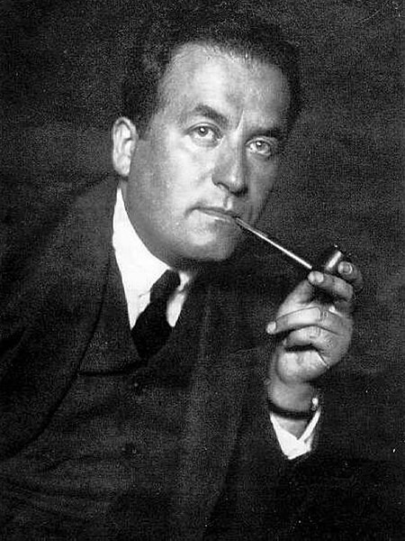 Black and white photo of a man smoking a pipe.