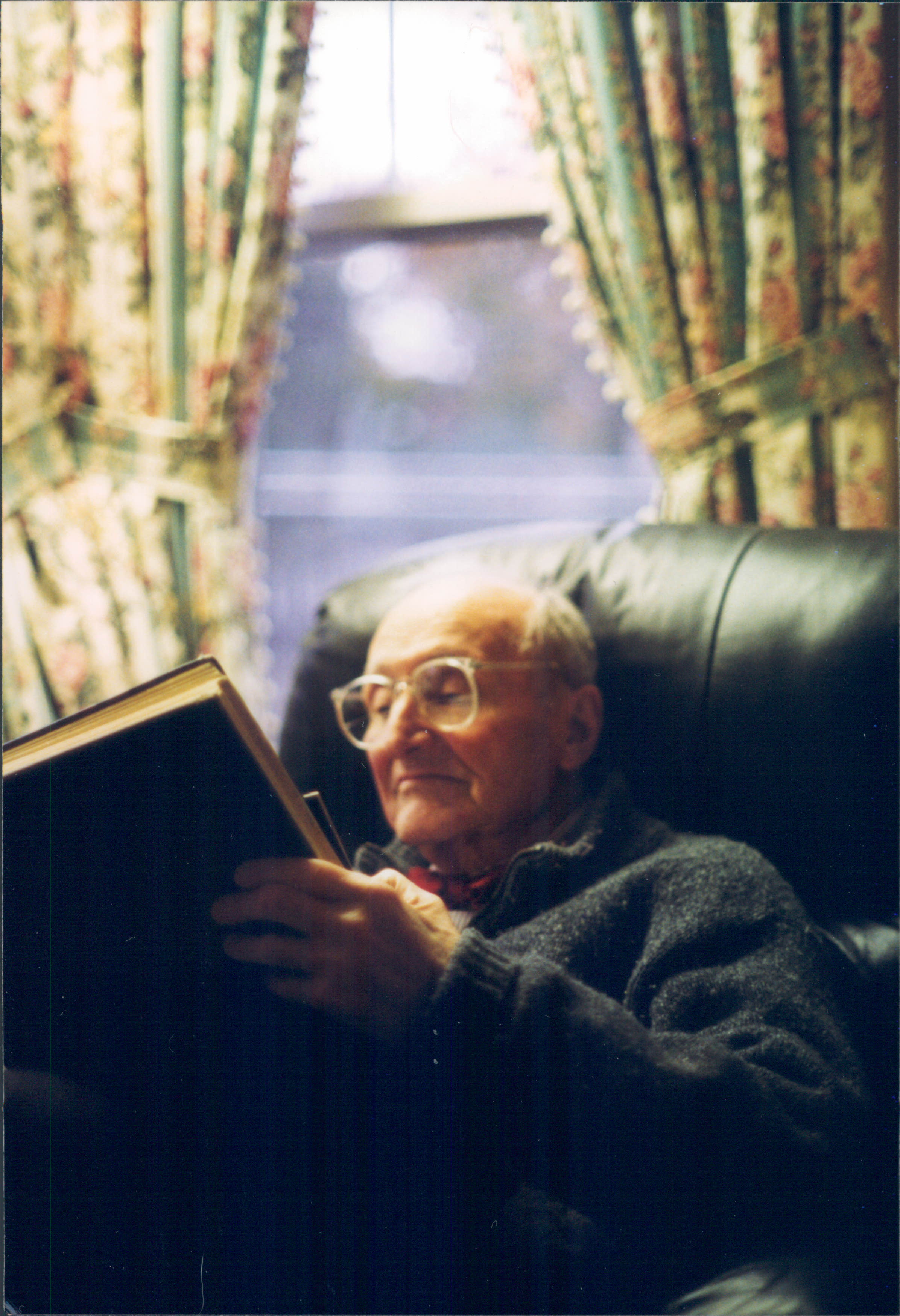 Older man reading in a comfortable chair.